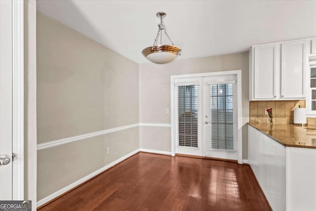 1101 Collier Rd NW Unit K2, Atlanta, GA 30318 - kitchen with appliances with stainless steel finishes, a peninsula, dark stone countertops, and tasteful backsplash