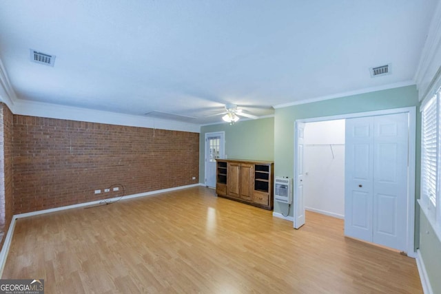 675 Mountain View Dr, Thomaston, GA 30286 - unfurnished living room with brick wall, heating unit, light wood finished floors, ceiling fan, and ornamental molding