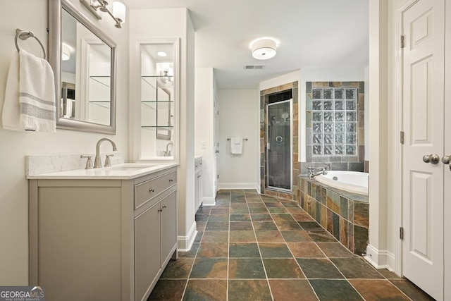 10310 Amberside Ct, Roswell, GA 30076 - bathroom with stone tile flooring, two vanities, a shower stall, baseboards, and a garden tub