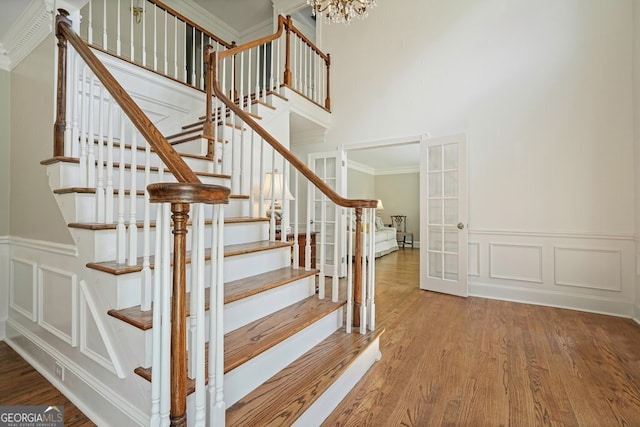 10310 Amberside Ct, Roswell, GA 30076 - stairway with a decorative wall, wood finished floors, a wainscoted wall, a towering ceiling, and crown molding
