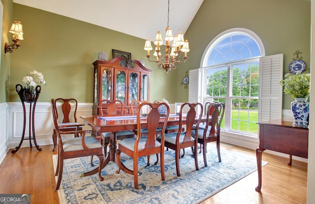 150 Bay Dr, Newnan, GA 30263 - dining space with high vaulted ceiling, a chandelier, light wood-type flooring, and a wainscoted wall