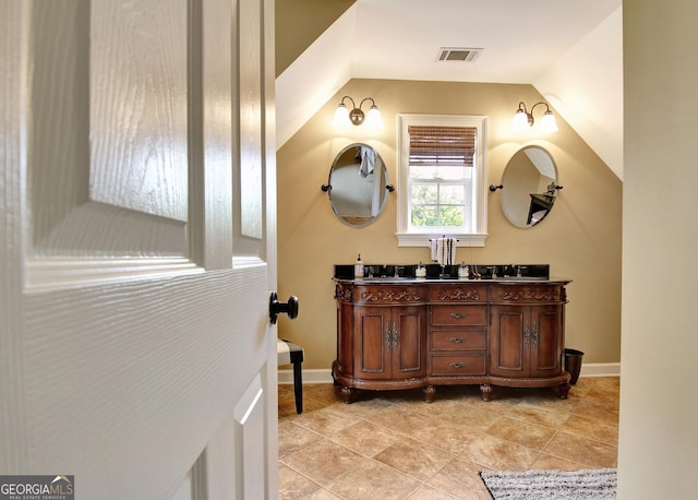 150 Bay Dr, Newnan, GA 30263 - bathroom with vaulted ceiling, double vanity, and baseboards