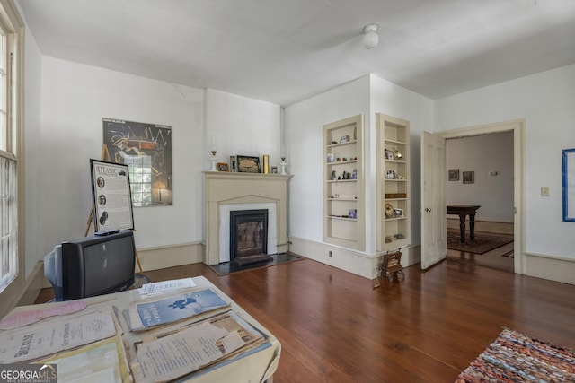 171 N Jefferson Ave, Talbotton, GA 31827 - living room featuring a glass covered fireplace, built in features, and wood finished floors