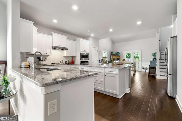 75 Georgian Oaks Ct, Newnan, GA 30265 - kitchen with stainless steel appliances, a sink, a peninsula, white cabinetry, and recessed lighting