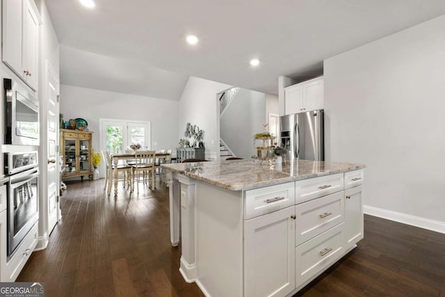 75 Georgian Oaks Ct, Newnan, GA 30265 - kitchen featuring stainless steel appliances, dark wood-type flooring, light stone counters, white cabinetry, and recessed lighting