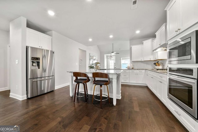 75 Georgian Oaks Ct, Newnan, GA 30265 - kitchen featuring appliances with stainless steel finishes, light stone counters, a peninsula, white cabinets, and recessed lighting