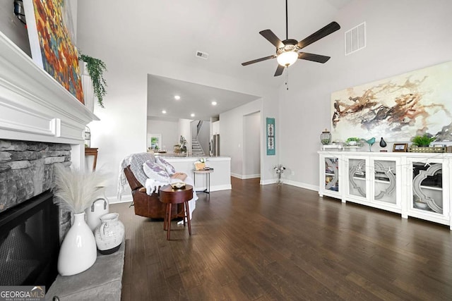 75 Georgian Oaks Ct, Newnan, GA 30265 - living area with ceiling fan, dark wood finished floors, a fireplace, high vaulted ceiling, and stairway