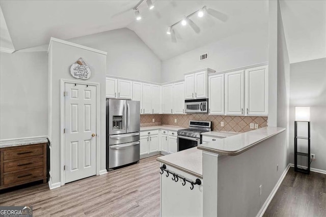 613 Wiley Ct, Canton, GA 30115 - kitchen featuring stainless steel appliances, light countertops, white cabinets, a peninsula, and light wood finished floors