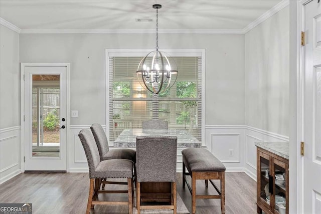 613 Wiley Ct, Canton, GA 30115 - dining room featuring wood finished floors, a chandelier, a decorative wall, ornamental molding, and a wainscoted wall
