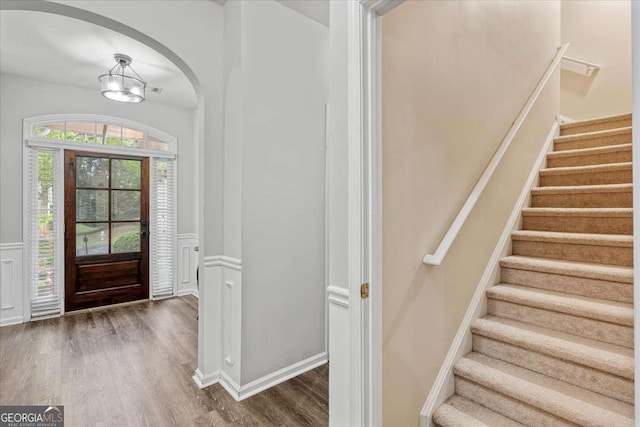 613 Wiley Ct, Canton, GA 30115 - entrance foyer featuring wood finished floors, stairway, wainscoting, arched walkways, and a chandelier