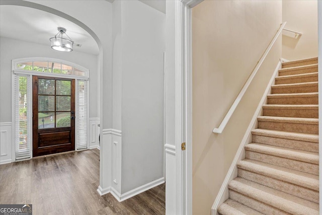 613 Wiley Ct, Canton, GA 30115 - foyer entrance with wood finished floors, stairway, wainscoting, arched walkways, and a chandelier