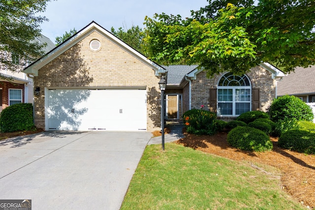 single story home featuring brick siding, an attached garage, and concrete driveway
