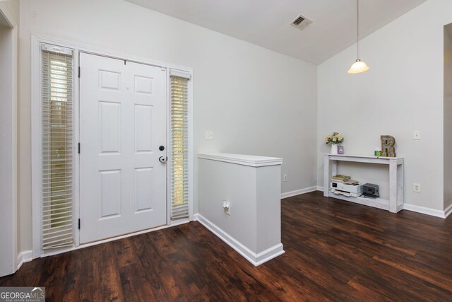 foyer entrance featuring wood finished floors, baseboards, and vaulted ceiling