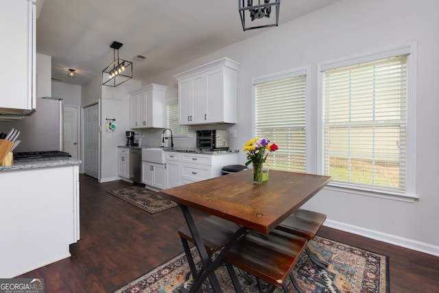 dining space featuring dark wood-type flooring and baseboards
