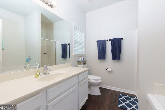 full bath with an enclosed shower, wood finished floors, vanity, baseboards, and toilet