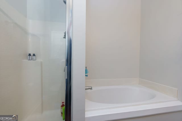 bathroom featuring a garden tub and a stall shower