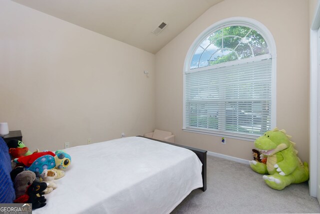 carpeted bedroom with lofted ceiling and baseboards