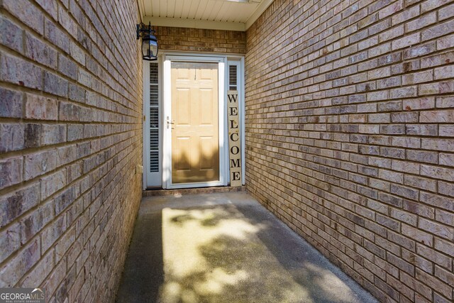view of exterior entry featuring brick siding