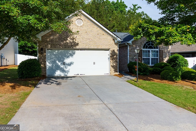 view of front of house with brick siding, driveway, and a garage