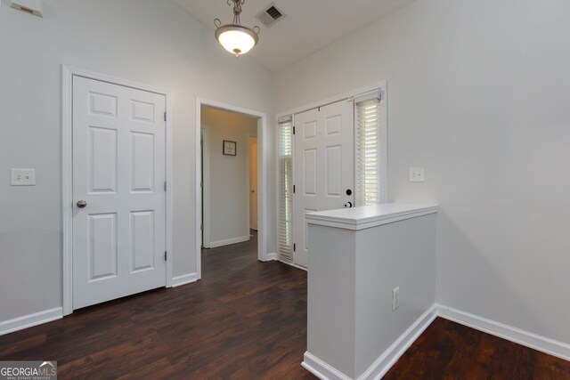 foyer with dark wood-type flooring and baseboards