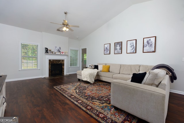 living room with a ceiling fan, plenty of natural light, dark wood-type flooring, a fireplace, and high vaulted ceiling