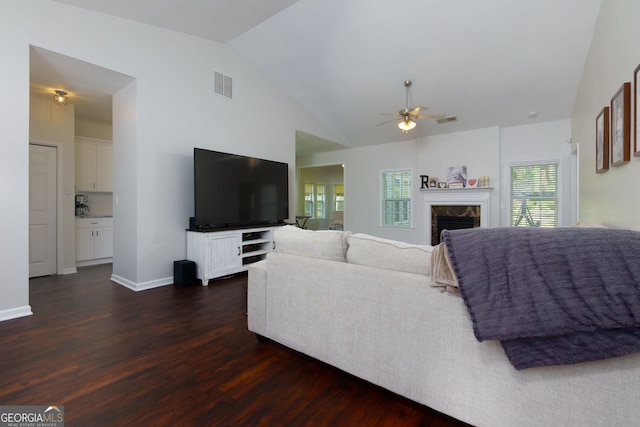 living area with a ceiling fan, lofted ceiling, dark wood finished floors, a high end fireplace, and baseboards