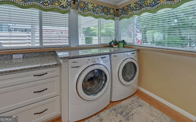 washroom with washing machine and dryer, crown molding, baseboards, and light wood-type flooring