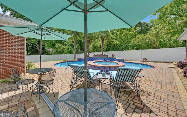 view of pool featuring a fenced backyard, an outdoor hot tub, and a patio area