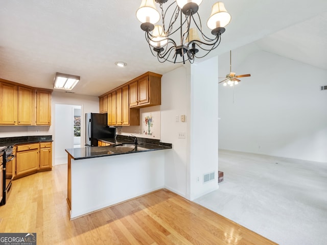 2910 Waverly Place Dr, Dacula, GA 30019 - kitchen featuring black appliances, a sink, dark countertops, light wood-type flooring, and a peninsula