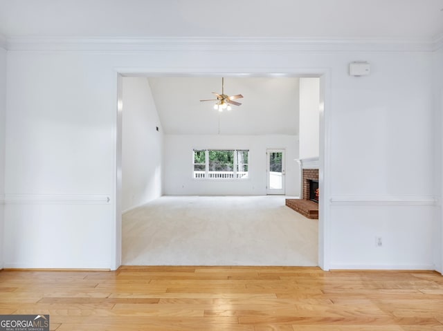 2910 Waverly Place Dr, Dacula, GA 30019 - unfurnished living room with light wood-type flooring, vaulted ceiling, a ceiling fan, a brick fireplace, and baseboards