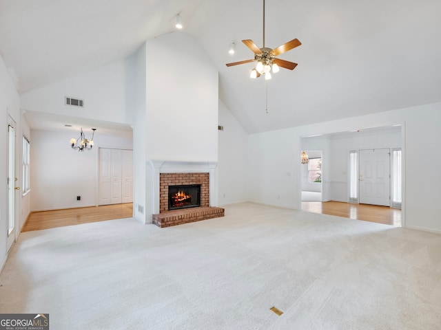 2910 Waverly Place Dr, Dacula, GA 30019 - unfurnished living room featuring high vaulted ceiling, a chandelier, carpet floors, a fireplace, and a ceiling fan