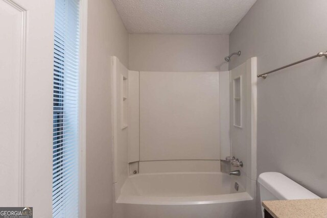 6015 Sumit Ct NW, Kennesaw, GA 30152 - bathroom with shower / bathtub combination, a textured ceiling, vanity, and toilet