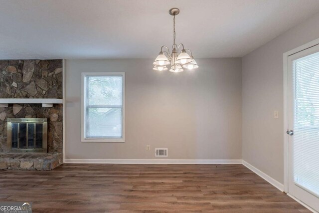 6015 Sumit Ct NW, Kennesaw, GA 30152 - unfurnished living room featuring wood finished floors, a chandelier, baseboards, and a stone fireplace