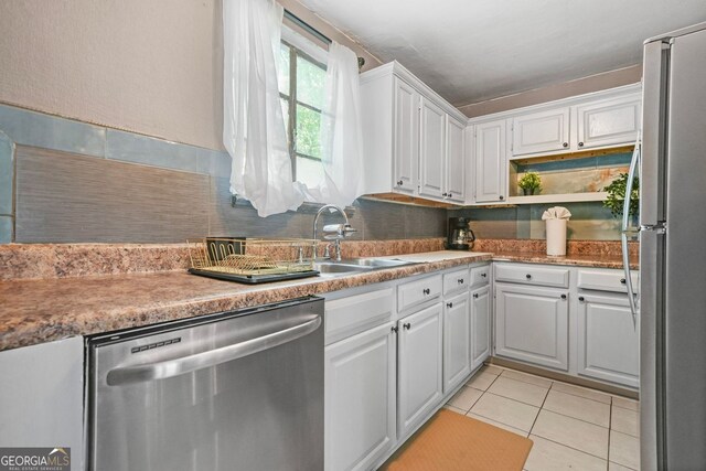 210 Estoria St SE, Atlanta, GA 30316 - kitchen featuring appliances with stainless steel finishes, white cabinetry, light tile patterned floors, tasteful backsplash, and light countertops