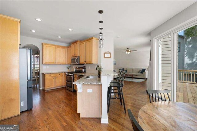 101 Misty Valley Dr, Canton, GA 30114 - kitchen featuring appliances with stainless steel finishes, light brown cabinets, ceiling fan, a sink, and arched walkways