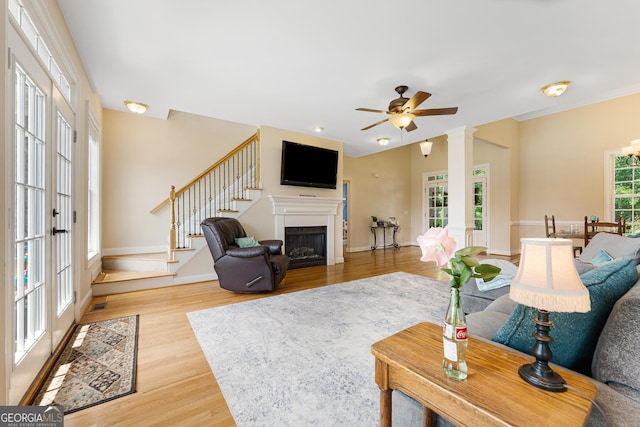 85 Majestic Shores Trl, Hartwell, GA 30643 - living area featuring ornate columns, stairs, light wood finished floors, ceiling fan, and baseboards