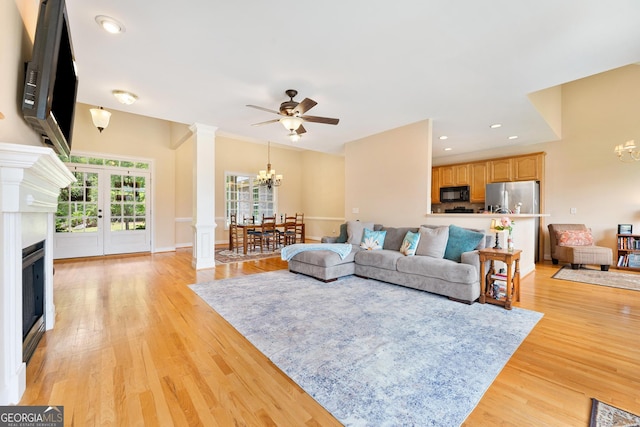 85 Majestic Shores Trl, Hartwell, GA 30643 - living area featuring a chandelier, a glass covered fireplace, light wood-type flooring, and ornate columns