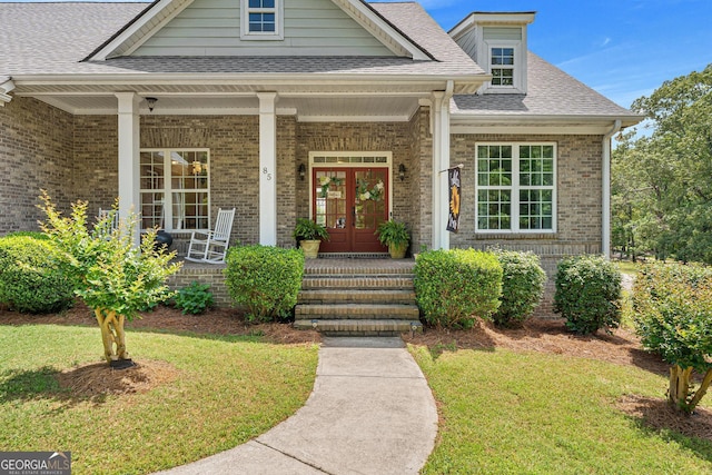 85 Majestic Shores Trl, Hartwell, GA 30643 - entrance to property featuring covered porch, brick siding, a lawn, a shingled roof, and french doors