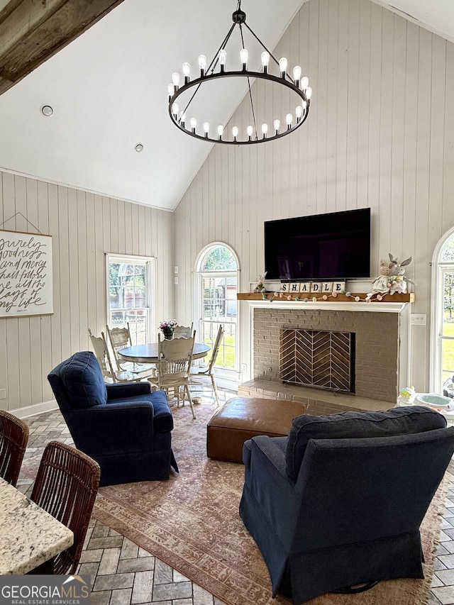 34 Pine Grove Rd, Cartersville, GA 30120 - living room featuring plenty of natural light, wood walls, a chandelier, high vaulted ceiling, and a brick fireplace