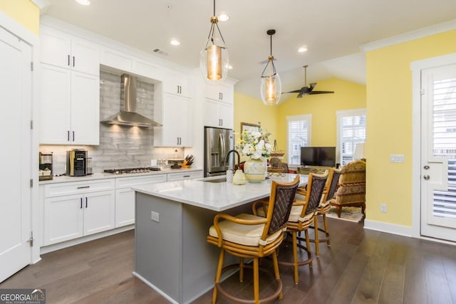 963 S On Main Dr, Woodstock, GA 30188 - kitchen featuring wall chimney range hood, appliances with stainless steel finishes, a sink, backsplash, and dark wood finished floors