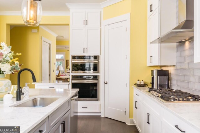 963 S On Main Dr, Woodstock, GA 30188 - kitchen featuring wall chimney exhaust hood, a sink, appliances with stainless steel finishes, backsplash, and light stone countertops
