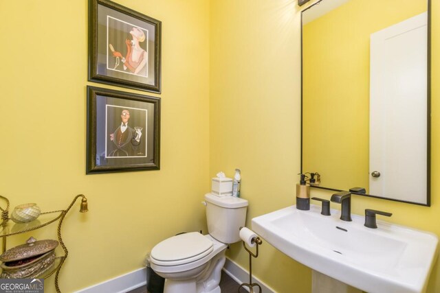 963 S On Main Dr, Woodstock, GA 30188 - half bathroom featuring baseboards, toilet, and a sink