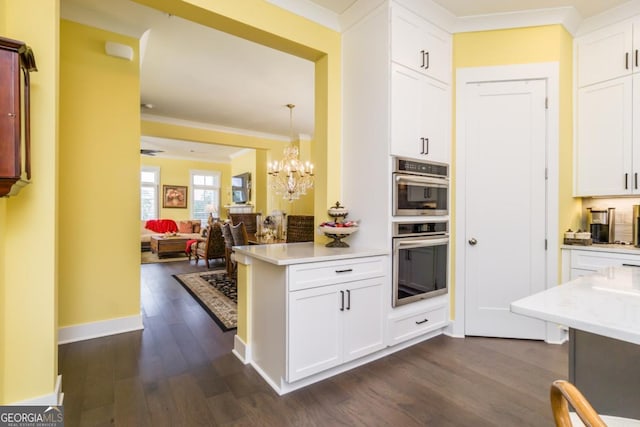 963 S On Main Dr, Woodstock, GA 30188 - kitchen with dark wood finished floors, a chandelier, white cabinetry, open floor plan, and crown molding
