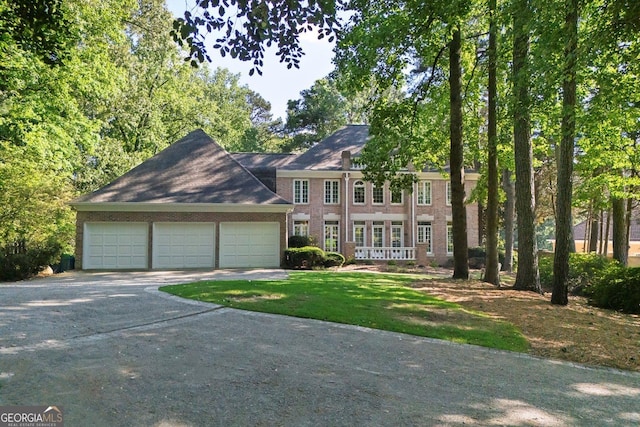 view of front of house with driveway, a garage, and brick siding