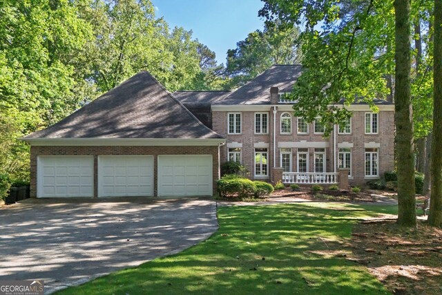 181 Sentinel Pl NE, Marietta, GA 30067 - view of front facade with brick siding, driveway, a garage, and a front lawn
