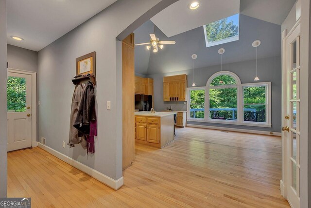 181 Sentinel Pl NE, Marietta, GA 30067 - kitchen with freestanding refrigerator, light countertops, light wood-type flooring, a skylight, and baseboards