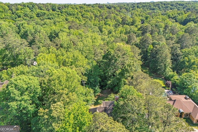 aerial view of property and surrounding area featuring a heavily wooded area