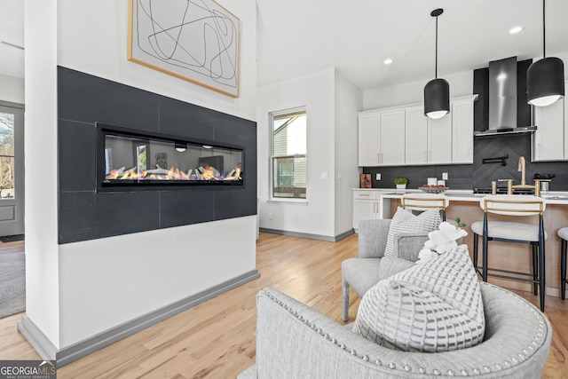 3378 Bachelor St, Atlanta, GA 30344 - kitchen featuring wall chimney exhaust hood, white cabinetry, light wood-type flooring, backsplash, and recessed lighting