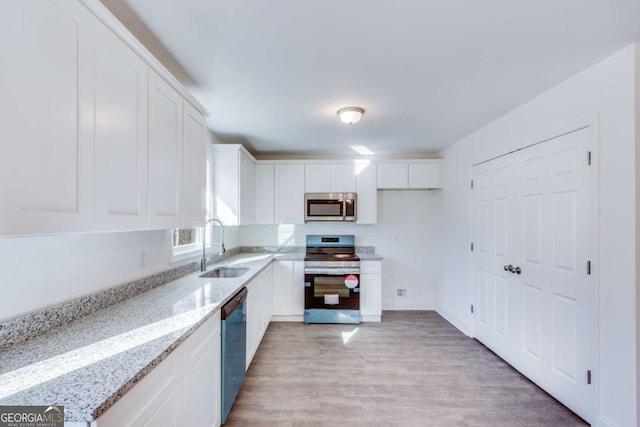 541 Day Star Ln, Mount Airy, GA 30563 - kitchen with appliances with stainless steel finishes, a sink, light stone countertops, and white cabinets