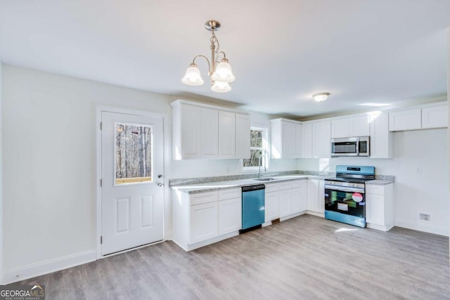 541 Day Star Ln, Mount Airy, GA 30563 - kitchen with stainless steel appliances, a chandelier, white cabinets, and baseboards